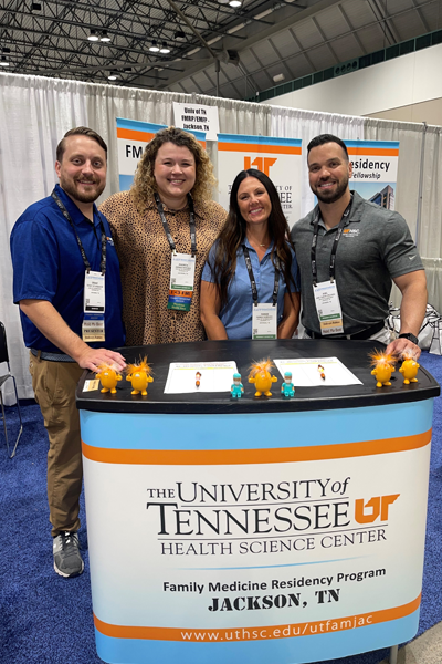 Three faculty members and a resident standing at the UTHSC booth