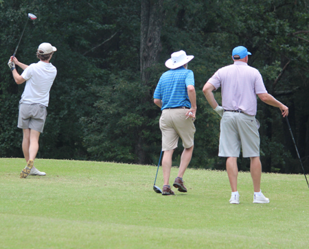 Backs of residents and faculty on the golf course