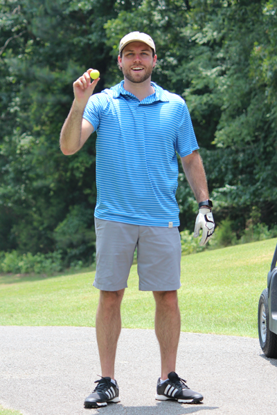 Resident holding a golf ball on the golf course