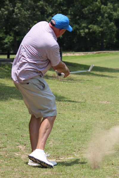 Program Director hitting a golf ball on the golf course