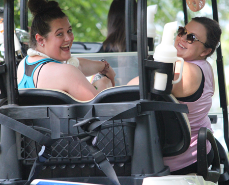 Two. female residents riding in a golf cart