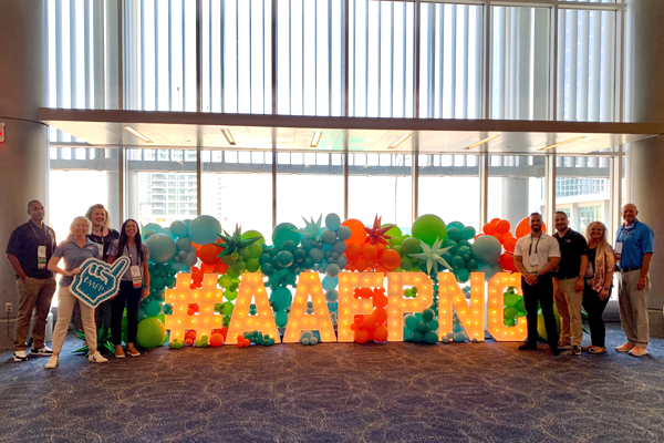 Faculty and residents standing next to the AAFPNC balloon sign