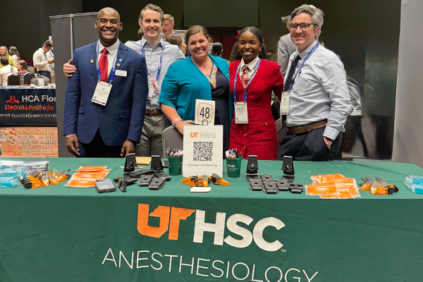 Faculty, residents, and manager at a UTHSC Anesthesiology table at a conference