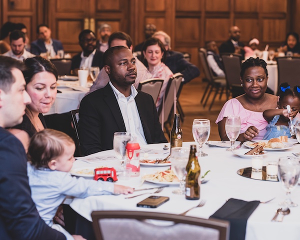 Fellows and faculty at tables with families