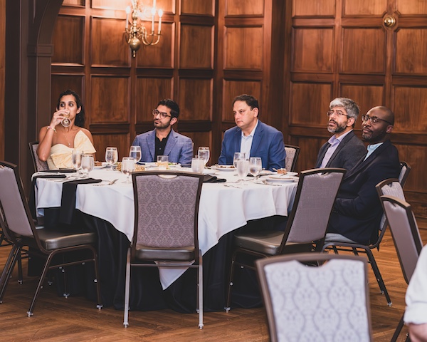 Faculty and fellows at tables during graduation