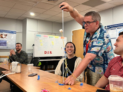 students working on a lab while a professor holds up a string