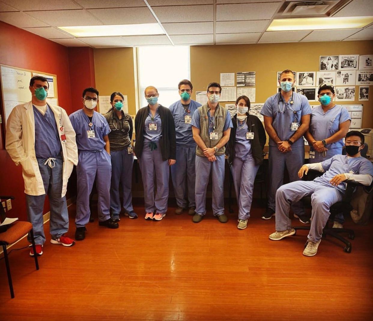 Group photo of residents in scrubs and masks