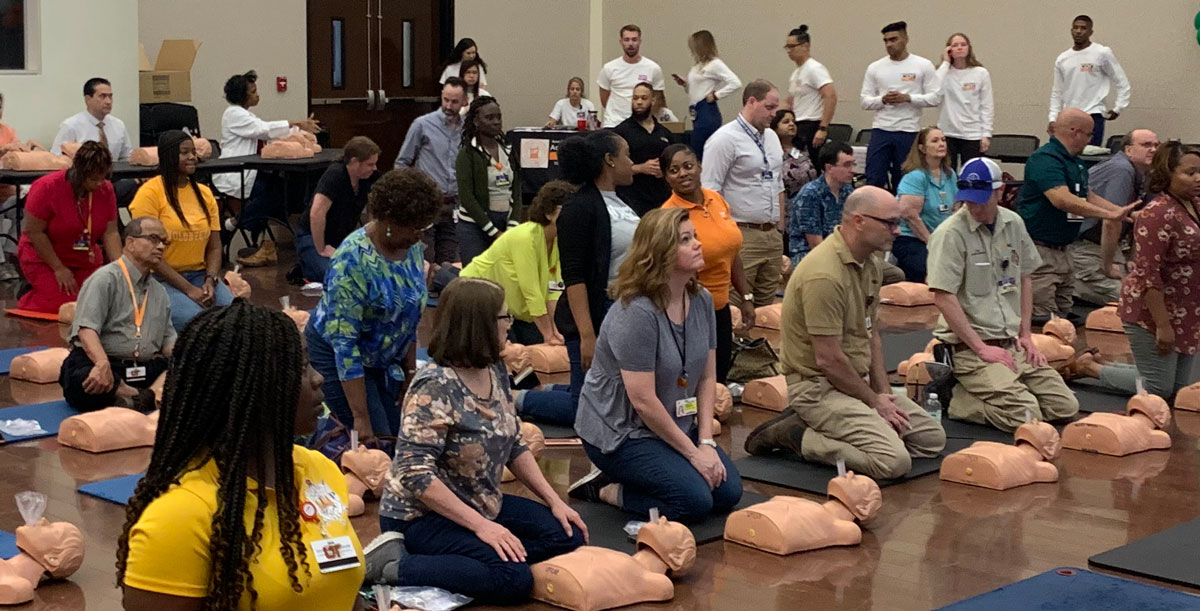 Group of staff and faculty participate in an AED/CPR training session.