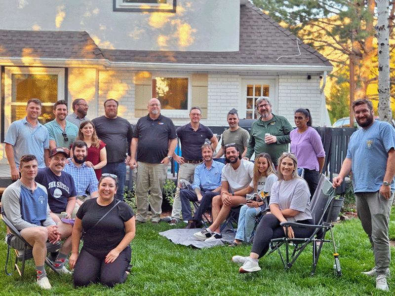 Emergency medicine residents gathered outdoors for a group photo in a backyard setting