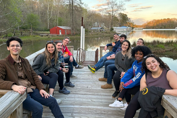 Residents sitting on a dock beside a lake