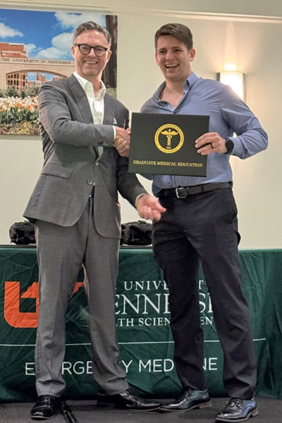 Graduating resident receiving his certificate from faculty