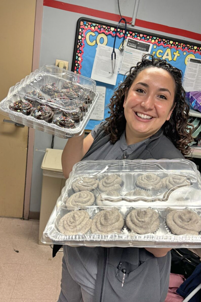 Female resident holding two boxes of cinnamon rolls