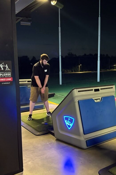 Male resident golfing at Top Golf