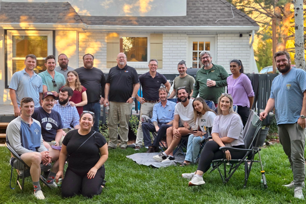 Residents and faculty outside a house in the late afternoon