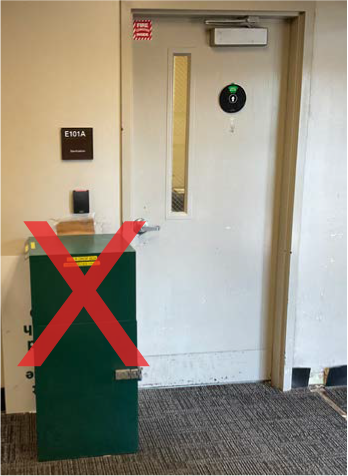 Example of an item blocking a braille/tactile sign which should never happen.