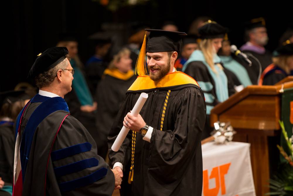 Student accepting diploma from Dean Alway
