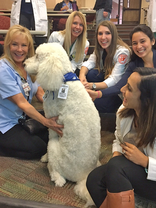 Five female residents with a white therapy dog