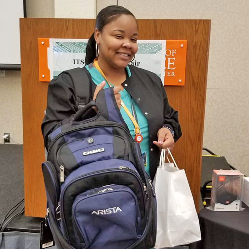 Female prize winner holding a backpack