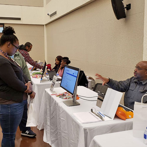 A lady looking at technology at a vendor's table