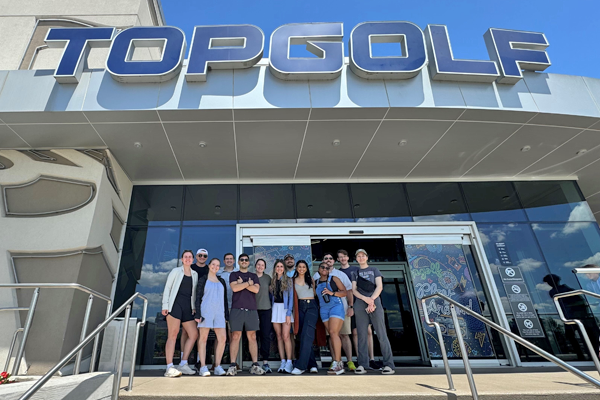 Group of residents standing at the entrance of TopGolf building