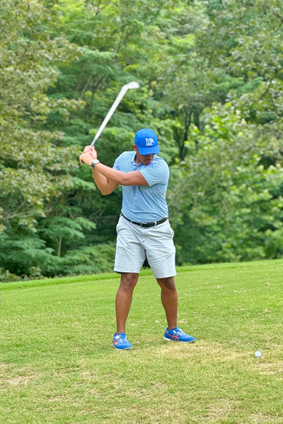 Male resident swinging a golf club