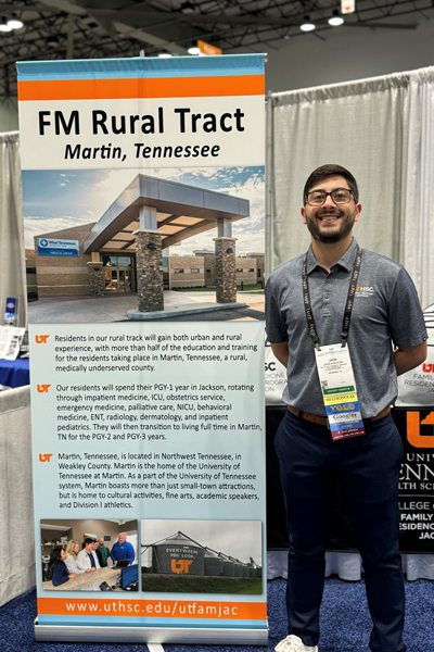 Resident in front of the FM rural tract banner at the conference