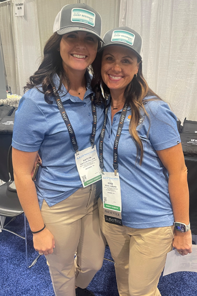 Two female residents wearing hats and matching shirts in an indoor environment