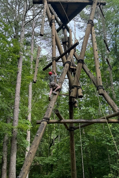 residents climbing up the ropes course