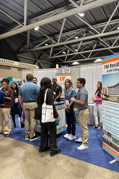 Residents and faculty in front of the Family Medicine booth
