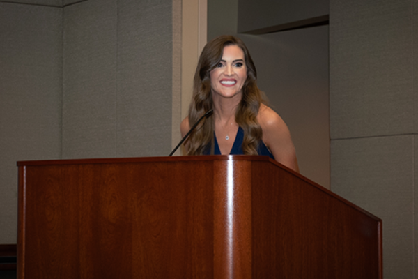 Female faculty member speaking at the podium