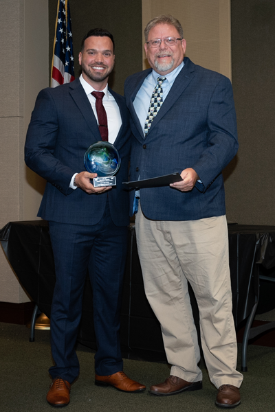 Faculty standing with a resident holding an award