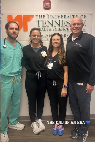 Residents and program manager in front of a UTHSC sign