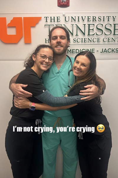 3 residents in front of a UTHSC sign