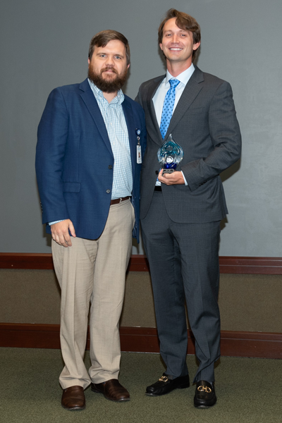 Faculty and resident hold an award at graduation