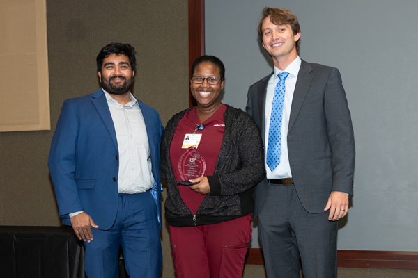 Faculty and resident with an award at Graduation