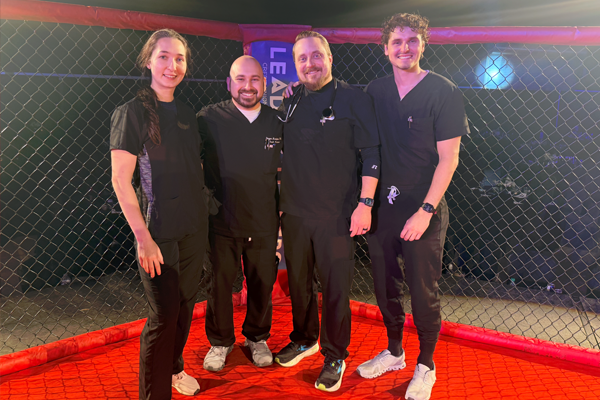 Residents and faculty standing inside a boxing ring