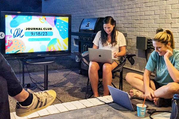 Two females on laptops are journal club