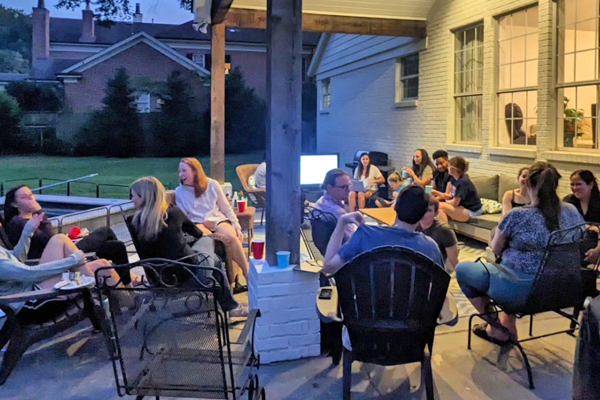 Residents sitting on a porch outdoors at journal club