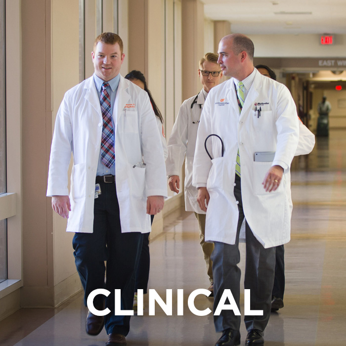 Resident walk down the hall of hospital with attending doctor. The word "clinical" is imposed on top of the photo.