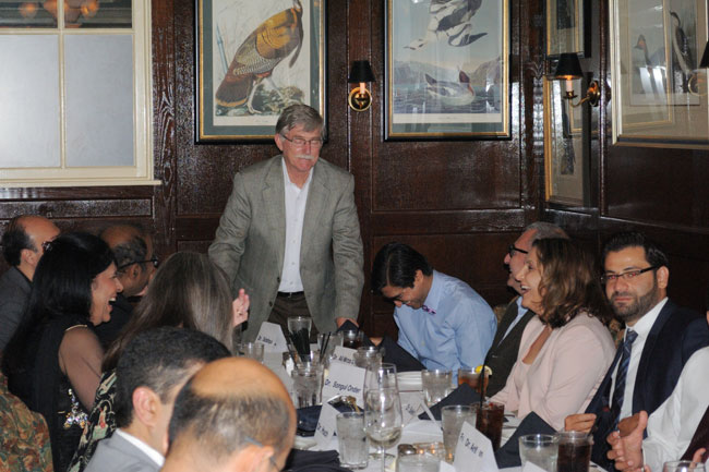 Dr. Wall addressing laughing faculty, fellows, and guests at the table