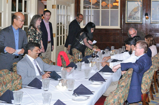 Faculty, fellows, and guests talking at a table