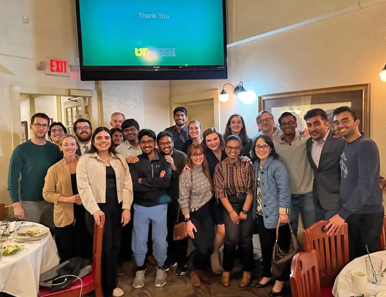Group of residents in a living room with a large screen television above them