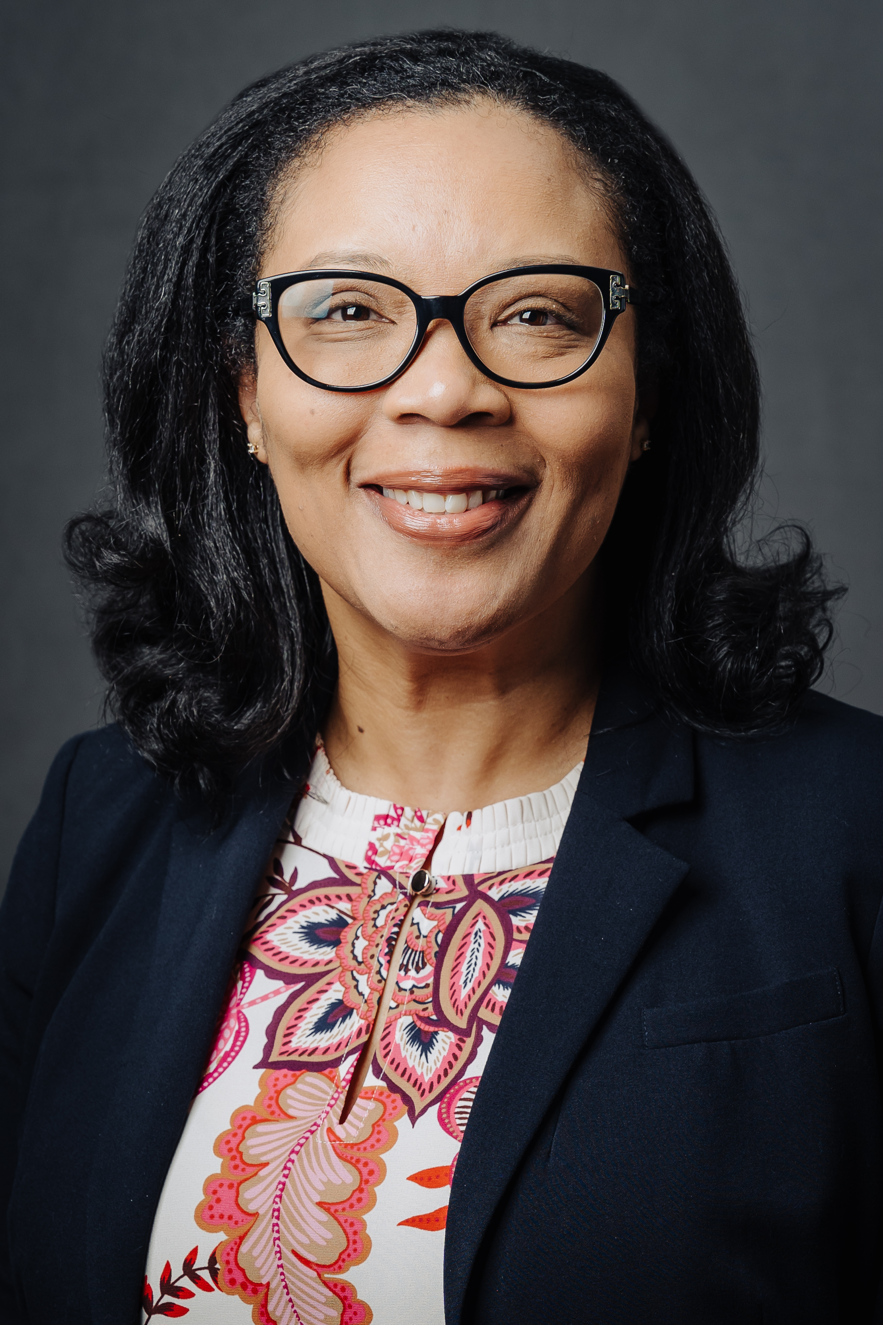 Woman with black hair and glasses