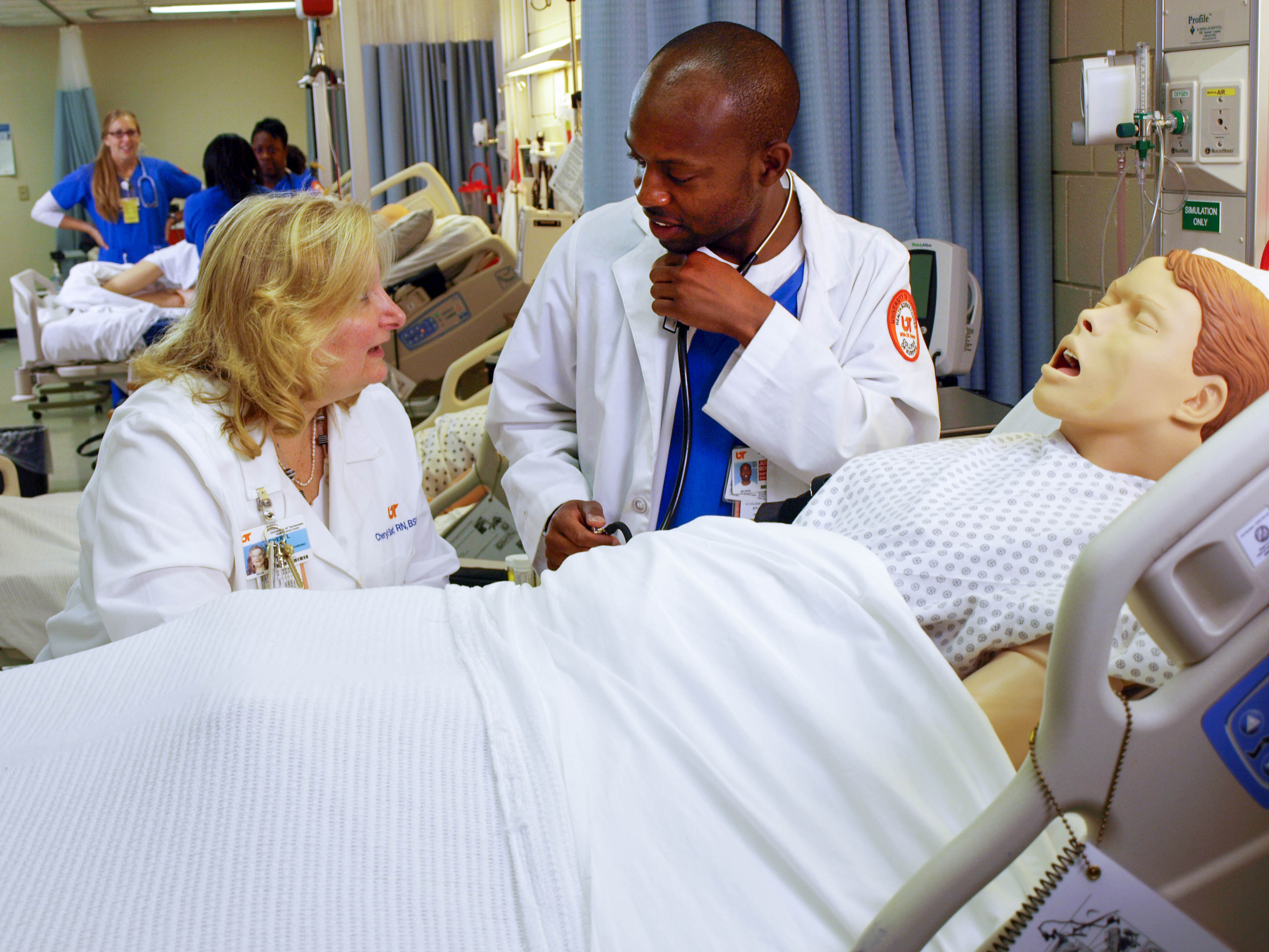 Nursing student receives instruction in simulation lab.