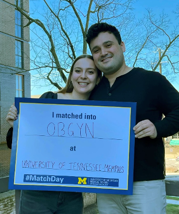 Resident and spouse with match sign