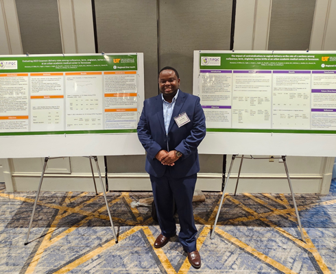 Resident in front of presentation posters