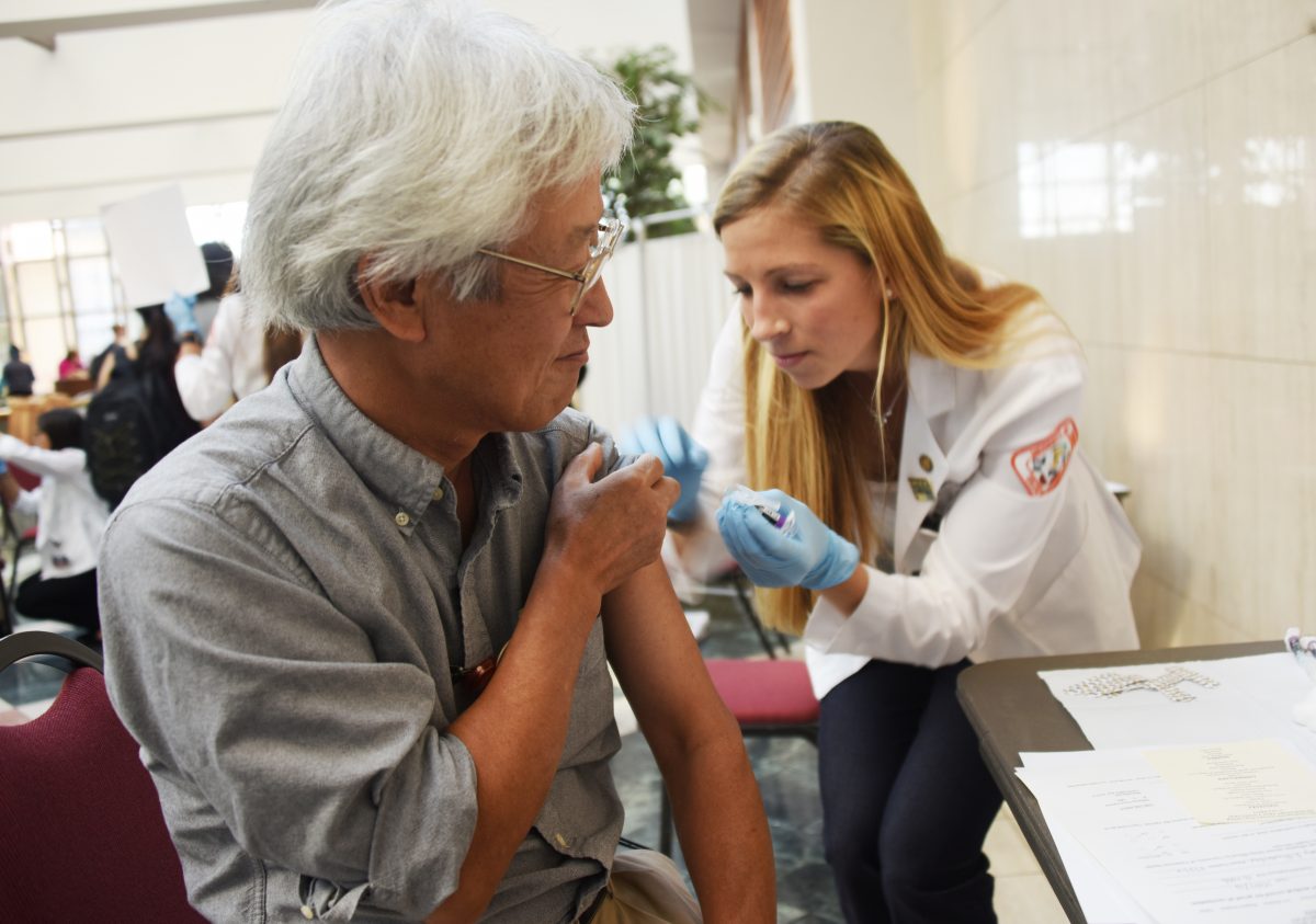 A student in the UTHSC College of Pharmacy administers a flu shot at Boo Flu