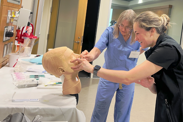 Resident working on a mannequin head under faculty supervision