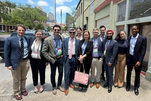 Faculty/residents posing on a sidewalk outside in a city setting