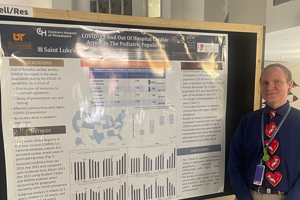 Resident in front of a presentation poster